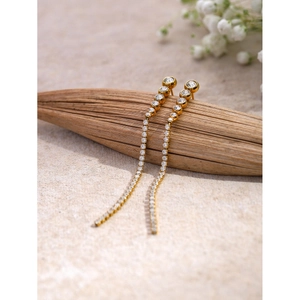 Macro detail of 18k gold tassels earrings with sparkling round zircon in a linear design