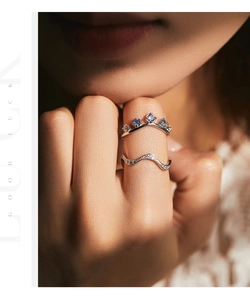 Macro shot of stacking silver crown ring with blue gemstones and sparkling wave band