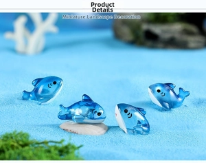 Miniature resin blue shark figurines set on blue sand with seashells and moss decor