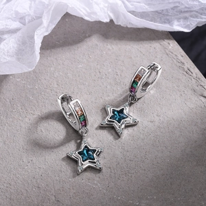 Detailed close-up of silver star earrings with blue crystals and multi-color gems