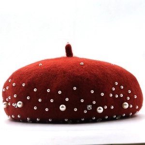 Detailed view of red wool beret with embedded white pearls and sparkling rhinestones