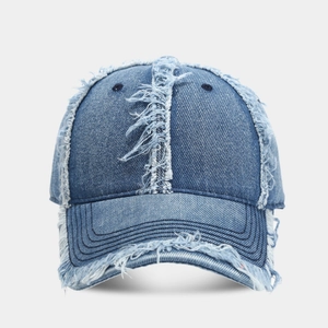 Détails des bords effilochés sur une casquette en jean bleu avec texture rétro usée