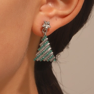 Detail of silver Christmas tree stud earring with green crystals on a model's ear