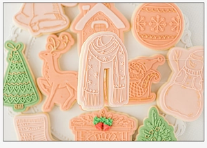 Detailed pastel Christmas cookies with icing patterns of reindeer, trees and scarves