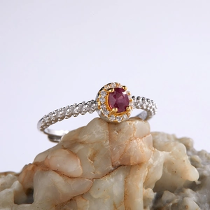 Detailed macro view of S925 silver ring featuring red oval gemstone on a natural rock surface