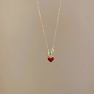 Detail of 18k gold plated necklace featuring a red heart pendant and colorful beads