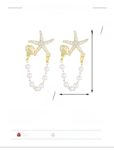 Detail view of gold starfish and shell earrings with pearl tassels and size dimensions
