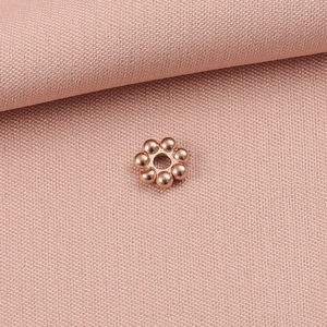 Makroaufnahme der roségoldenen Edelstahl-Zwischenperle in Blumenform für DIY-Schmuck