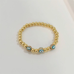 18K gold beaded bracelet with blue evil eye charms and sparkling pavé crystals