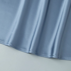 Close-up of light blue satin fabric showing smooth texture and fine hem stitching