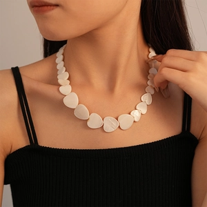 Close-up of elegant heart-shaped shell necklace worn by a model on a black top