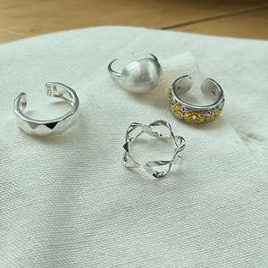 Close-up of S925 sterling silver rings showing certification mark on textured fabric