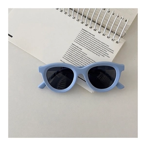 Close-up of light blue kids polarized sunglasses placed on a minimalist white notebook