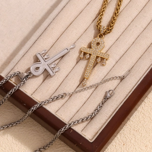 Close-up of gold and silver Ankh cross pendants with melting effect and pavé crystals