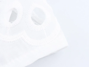 Close-up of white lantern sleeve with delicate embroidery and cutout lace detailing