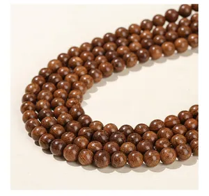Macro view of polished dark brown sandalwood beads with natural fine wood grain texture