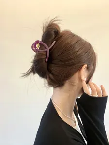 Pince à cheveux violette au design croisé élégant portée sur l'arrière de la tête