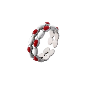 Detailed macro view of silver-tone double-row ring with red and white enamel accents