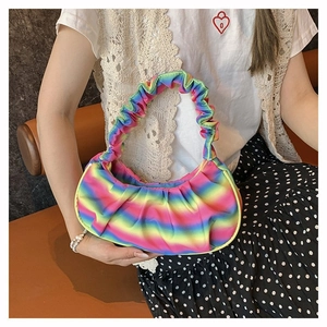 Detail of colorful rainbow gradient pleated shoulder bag showing soft fabric texture
