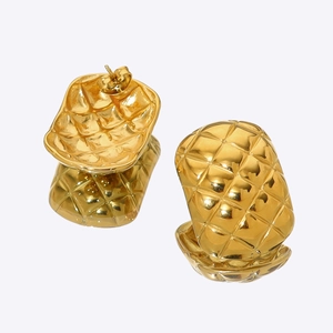 Macro view of square gold earrings featuring a classic quilted lattice texture