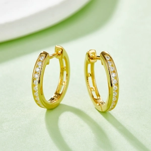 Macro shot of 18k gold plated silver hoop earrings with channel-set moissanite stones