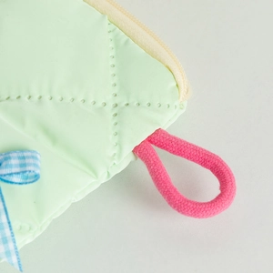 Detail der mintgrünen gesteppten Tasche mit rosa Kordelgriff und karierter Schleife