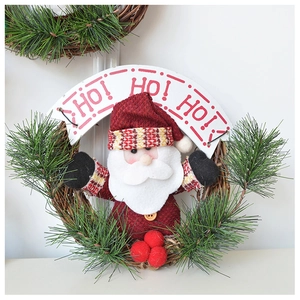 Detail of Christmas wreath with Santa plush, pine needles, and HO HO HO decorative sign