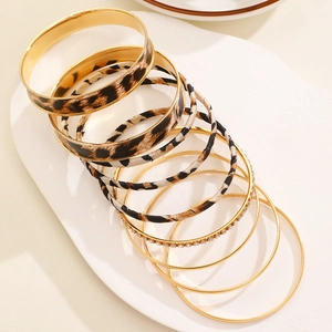 Detailed view of layered leopard print and gold tone stackable bracelet set on display