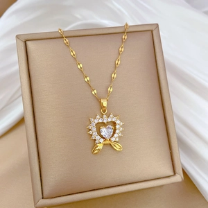 Detailed close-up of a golden heart necklace with white gemstones in a display box