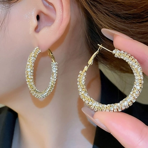 Macro shot of large golden hoop earrings with sparkling rhinestones and lever back closure