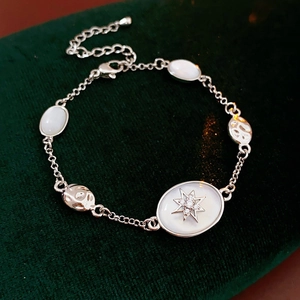 Close-up of a silver zircon star starburst bracelet with oval stones on green velvet