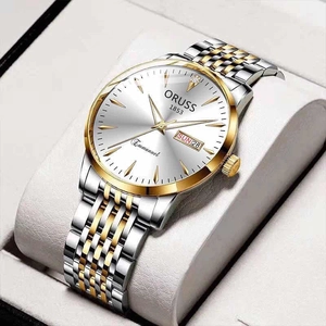 Macro shot of a dual-tone business watch featuring gold accents and date-day window display