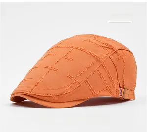 Close-up of orange textured knit beret with distressed edges and FASHION logo tag
