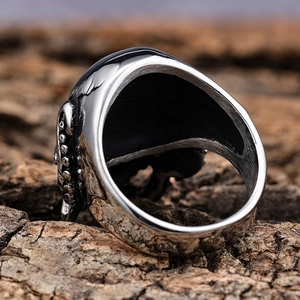 Vintage punisher skull stainless steel ring with gothic relief on natural wood background