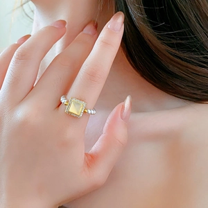 Close-up of 18k gold plated square gemstone ring with delicate pearl beaded band