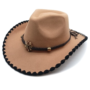 Detail of khaki felt cowboy hat with braided leather band and star metal ornament