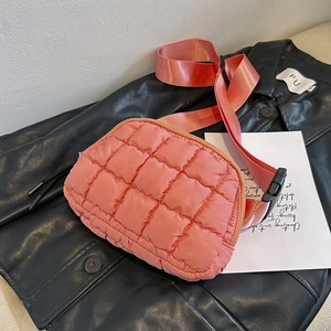 Pink quilted crossbody waist bag on a black leather jacket with adjustable wide strap