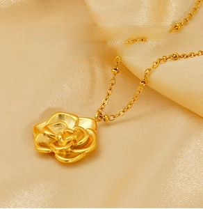 Vue macro détaillée du pendentif rose en acier inoxydable doré sur fond de soie douce