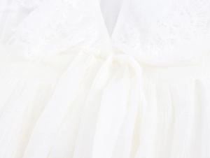 Détail du col en V avec dentelle blanche, nœud papillon et texture de tissu plissé