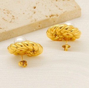 Detailed close-up of 18K gold braided twist pearl earrings on a silk textured surface