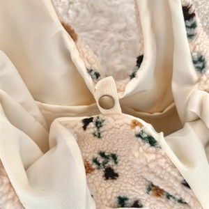 Detail view of the soft sherpa tote interior with secure bronze metal snap button closure