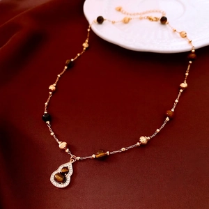 Gold plated necklace with tiger eye beads and pavé diamond gourd pendant on red silk