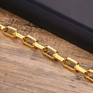 Macro shot of polished gold rectangular chain links showing high-gloss 18K finish