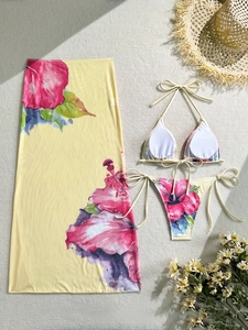 Flat lay of a 3-piece floral bikini set featuring a tropical sarong and pink hibiscus print