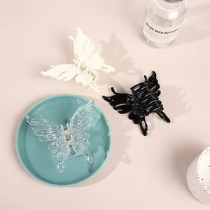 Detailed set of butterfly hair claws in black, white, and clear resin on a blue tray