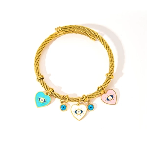 Detail of gold braided cable bracelet with colorful enamel evil eye heart charms