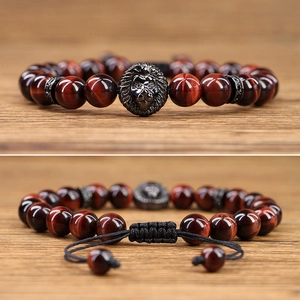 Detail van rode tijgeroog armband met een leeuwenkop bedel en verstelbare koordsluiting
