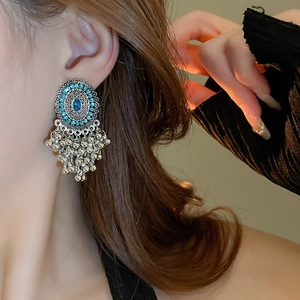 Close-up of bohemian silver earrings with blue gemstones and multi-layer dangles