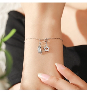 Close-up of 925 silver bracelet featuring bird owl and star pendants with micro-inlays