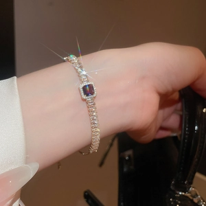 Gros plan d'un bracelet avec pierre carrée violette et zircons scintillants élégants